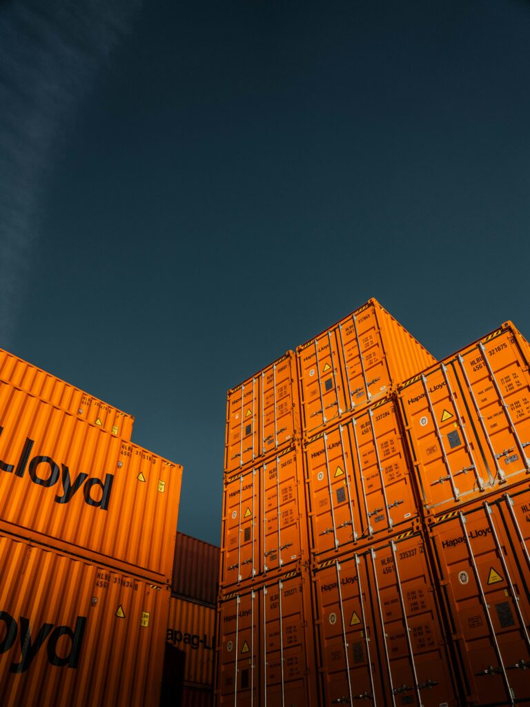 Orange shipping containers staged for cost-effective bulk ocean freight loading.